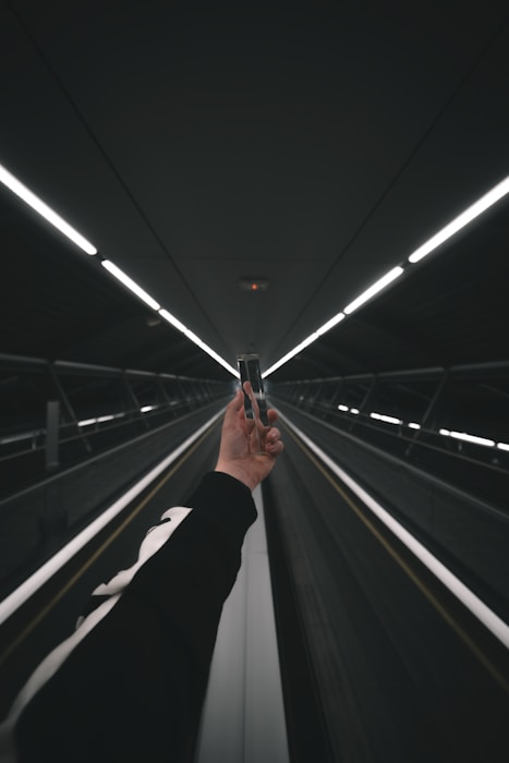 person in black pants walking on escalator